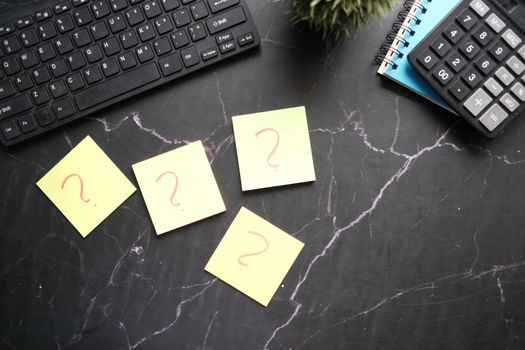 high angle view of question mark on paper on office desk.
