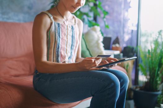 Cropped Shot of a beautiful African woman doing online banking from her sofa