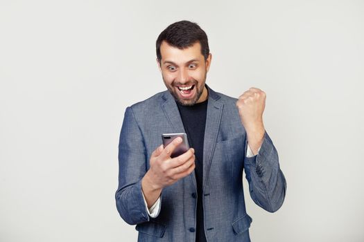 Young businessman man with beard with hand on headache due to stress. Suffering from migraines. Portrait of a man on a gray background.