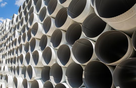 Downpipe warehouse. Steel pipes, parts for the construction of a roof drainage system in a warehouse. Stack of stainless steel pipes