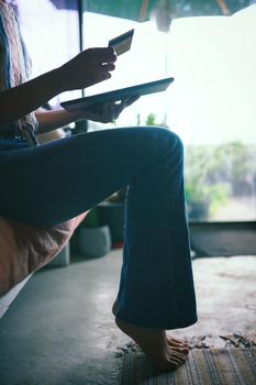 Silhouette Shot of hands holding a credit card and a tablet