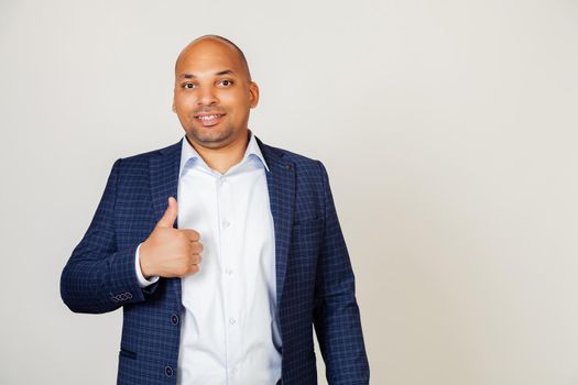Young African American man making gesture of approval and success with smiling happy hand gesture. An affirmative facial expression showing success, looking at the camera