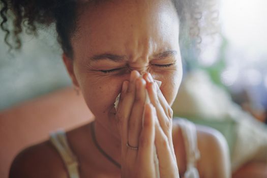 Close up shot of a young African woman blowing her nose