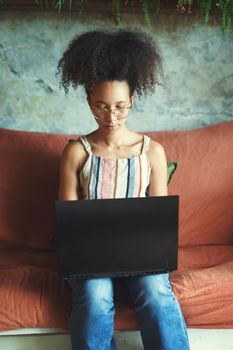 Shot of a beautiful young woman working from her sofa