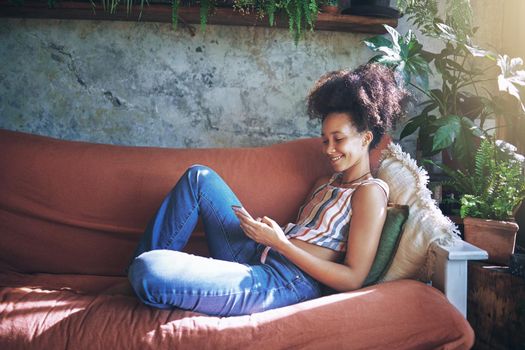 Shot of a beautiful African young woman relaxing at home - Stock Photo