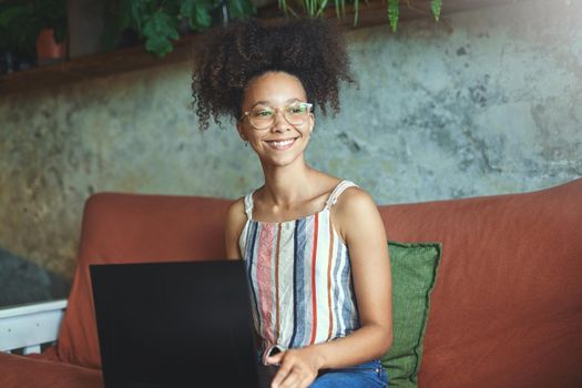 Shot of a beautiful young woman working from her sofa