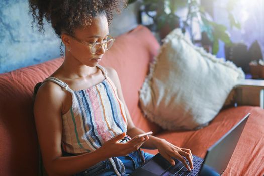 Shot of a beautiful African woman working from her living room