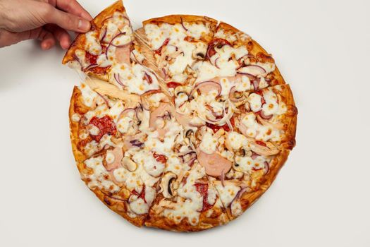 Man's hand takes a delicious slice of pizza with Margarita or Margarita with Mozzarella cheese, A man takes a slice of Italian pizza and pulls out an appetizing melted cheese.