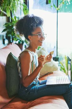 Shot of a beautiful African woman being cheerful on her couch