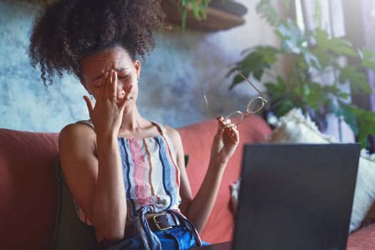 Shot of a beautiful young woman having a headache from her reading glasses