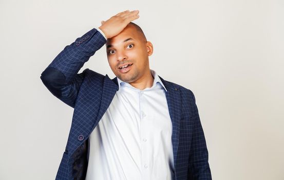Young African American man smiling positively, resting his hand on his head for a mistake, remember a mistake. Forgot, bad memory concept. Black man.