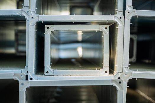 Ventilation pipes are square and rectangular. Steel pipes, parts for the construction of air ducts for an industrial air conditioning system in a warehouse. Industrial ventilation equipment