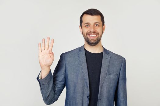 Young businessman man with beard smiling, showing number four with fingers on hand, smiling confidently and happily, looking into the camera. The man shows four fingers. Number 4
