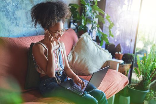 Shot of a beautiful African woman working from her living room