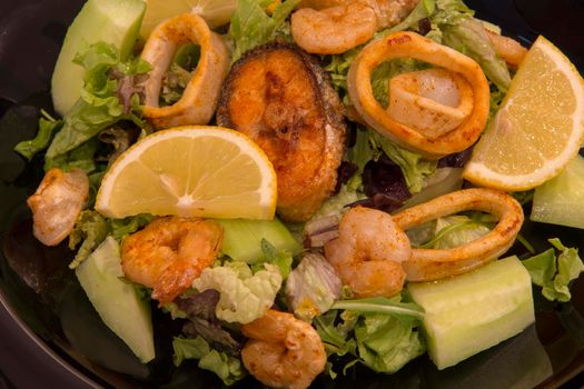 Tasty seafood. mixed salad shrimps, fish and squids with lemon and vegetables. Top view, appetizing food 