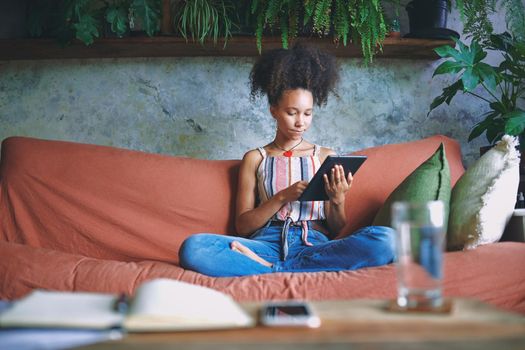 Shot of a beautiful African woman doing online shopping from her living room