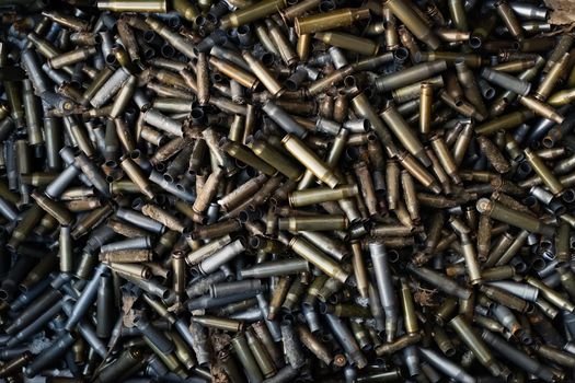 Empty carbine or rifle cartridges. A large number of cases. Background of brass ammunition cartridges to illustrate armed conflict, war or shooting