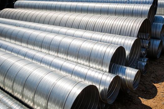 Ventilation pipe warehouse. Steel pipes, parts for the construction of air ducts for an industrial air conditioning system in a warehouse. Industrial airway ventilation equipment and piping systems.