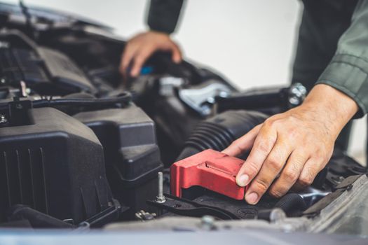 Professional mechanic hand providing car repair and maintenance service in auto garage. Car service business concept.