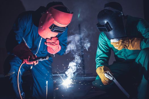 Metal welding steel works using electric arc welding machine to weld steel at factory. Metalwork manufacturing and construction maintenance service by manual skill labor concept.