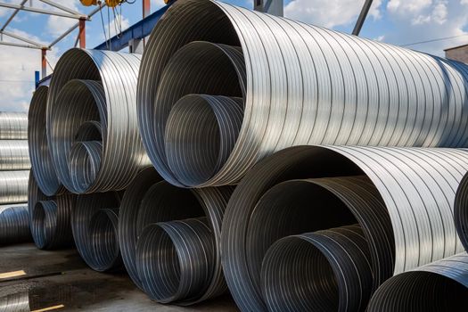 Ventilation pipe warehouse. Steel pipes, parts for the construction of air ducts for an industrial air conditioning system in a warehouse. Industrial airway ventilation equipment and piping systems.