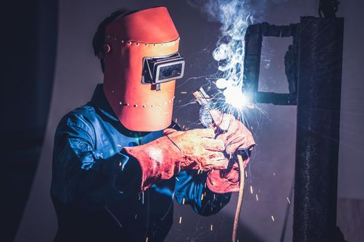 Metal welding steel works using electric arc welding machine to weld steel at factory. Metalwork manufacturing and construction maintenance service by manual skill labor concept.