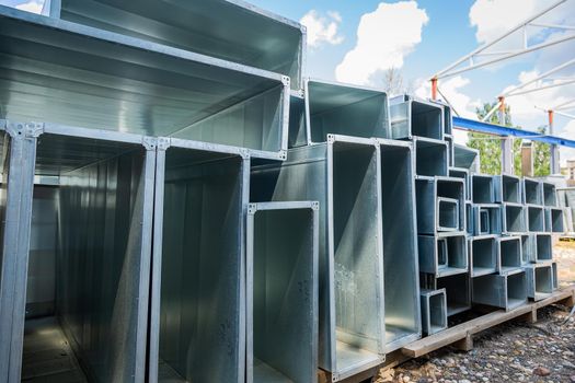 Ventilation pipes are square and rectangular. Steel pipes, parts for the construction of air ducts for an industrial air conditioning system in a warehouse. Industrial ventilation equipment