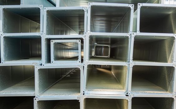 Ventilation pipes are square and rectangular. Steel pipes, parts for the construction of air ducts for an industrial air conditioning system in a warehouse. Industrial ventilation equipment
