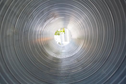 The ventilation pipe is round from the inside. Steel pipes, parts for the construction of industrial air conditioning ducts inside the pipe. Industrial ventilation equipment.
