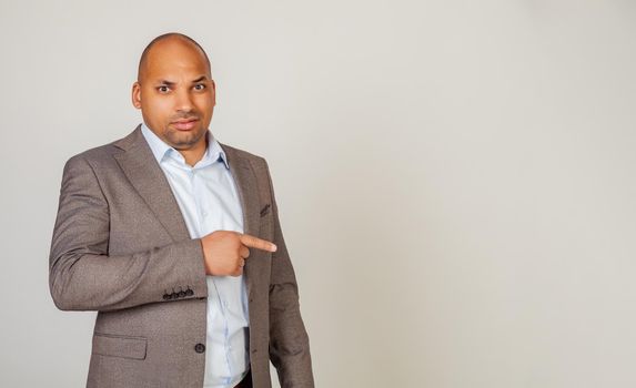 African man male discontent, expresses disgust and dislike points index finger to the side on copy space, disappointed with bad product with disgust. Copy space. Disgusting thing