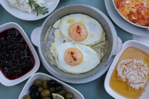 Organic, fresh traditional turkish village breakfast on wooden table with copper egg pan