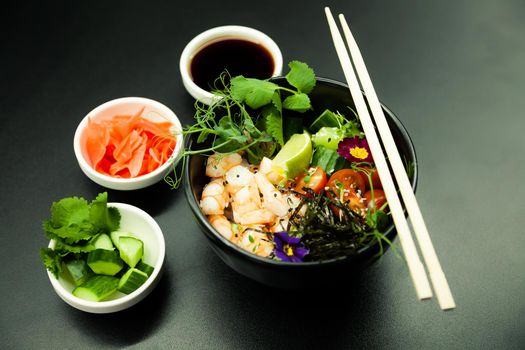 Poke salad with shrimp in a bowl. Ingredients Shrimp, blanched spinach, cherry tomatoes, rice, cucumber, soy-ginger sauce, Spicy sauce, nori, sesame, lime, cilantro. Asian seafood salad concept