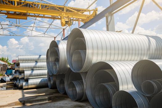 Ventilation pipe warehouse. Steel pipes, parts for the construction of air ducts for an industrial air conditioning system in a warehouse. Industrial airway ventilation equipment and piping systems.