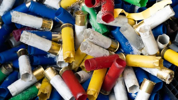 A large number of hunting blank cartridges of 12 gauge. Many shotgun cartridges in different colors with empty cartridges can be used as a textured background