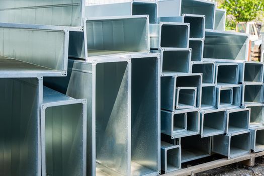 Ventilation pipe warehouse. Steel pipes, parts for the construction of air ducts for an industrial air conditioning system in a warehouse. Industrial airway ventilation equipment and piping systems.