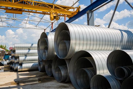 Ventilation pipe warehouse. Steel pipes, parts for the construction of air ducts for an industrial air conditioning system in a warehouse. Industrial airway ventilation equipment and piping systems.