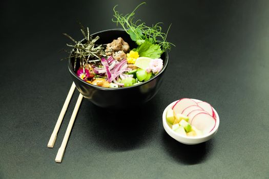 Poke salad with beef in a bowl. Ingredients Beef, Nameko mushrooms, cherry tomatoes, rice, cucumber, red onion, Kim Chi sauce, Ponzu sauce, nori, sesame seeds, cilantro, lime. Asian salad concept.