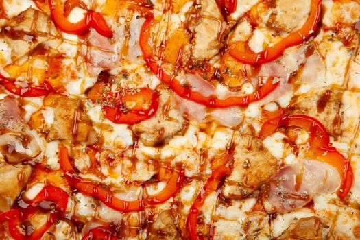 Texture pizza with bacon and chicken Teriyaki served on a wooden plate, ingredients Signature sauce, mozzarella cheese, Teriyaki chicken, bacon, bell pepper, Teriyaki sauce. Close-up.