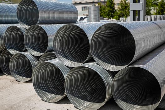 Ventilation pipe warehouse. Steel pipes, parts for the construction of air ducts for an industrial air conditioning system in a warehouse. Industrial airway ventilation equipment and piping systems.