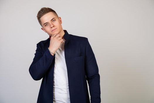 Handsome young man with stylish hairstyle looking at the camera with a smile on his face. Photo of young attractive handsome modern freelancer, entrepreneur, student looking at camera.