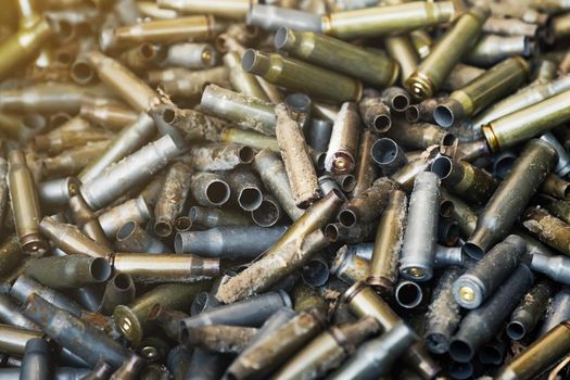 Empty carbine or rifle cartridges. A large number of cases. Background of brass ammunition cartridges to illustrate armed conflict, war or shooting