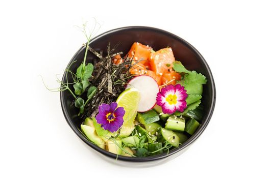 Poke with salmon in a bowl. Ingredients fresh salmon, avocado, cucumber, rice, Tamarind sauce, mango sauce, nori, lime, sesame seeds, cilantro. Seafood concept. Asian salmon poke salad on white plate.