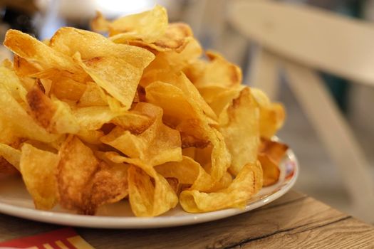 Many golden potatoes fried on the plate in a restaurant, french fries