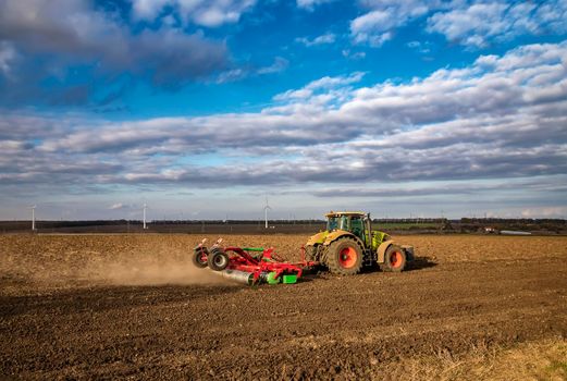 The tractor prepares the ground for sowing and cultivation. Agriculture and agronomy concept.