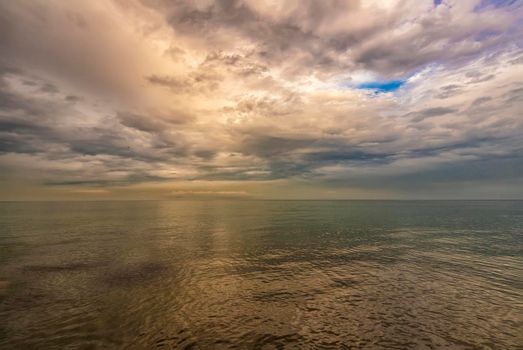 Exciting sea landscape. Beautiful colorful clouds over the calm sea.