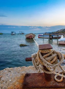 Amazing long exposure landscape at rope anchoring fishing boat at the pier.