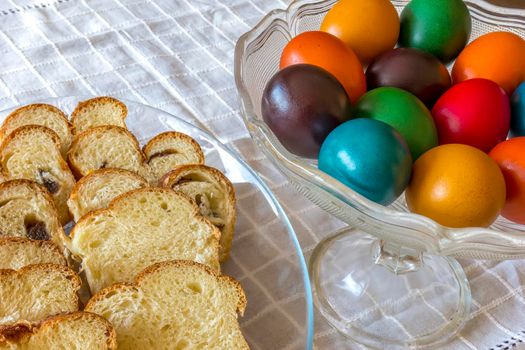 Easter traditional bread and colorful Easter eggs in a plate on the table