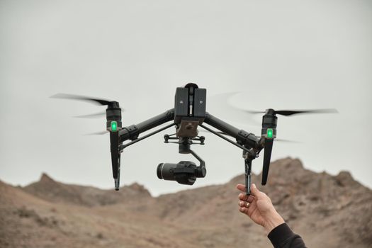 Men's hand catch a large professional drone, somewhere in the mountains, on video footage