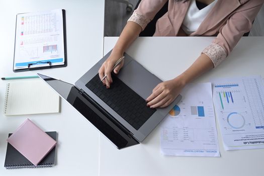 Overhead view businesswoman using laptop computer on office desk.