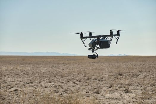 A professional drone flies into a field in nature and shoots a video,